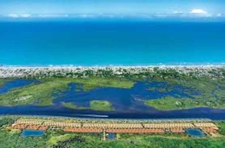 An aerial view shows a residential complex situated between a waterway, wetlands, and the ocean — 158 CORONADO ROAD, FLAGLER BEACH, FL