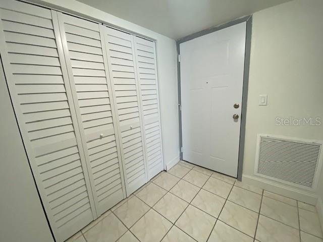 A tiled entryway features a white louvered closet door and a white front door — 542 PLAZA SEVILLE COURT UNIT 78, TREASURE ISLAND, FL