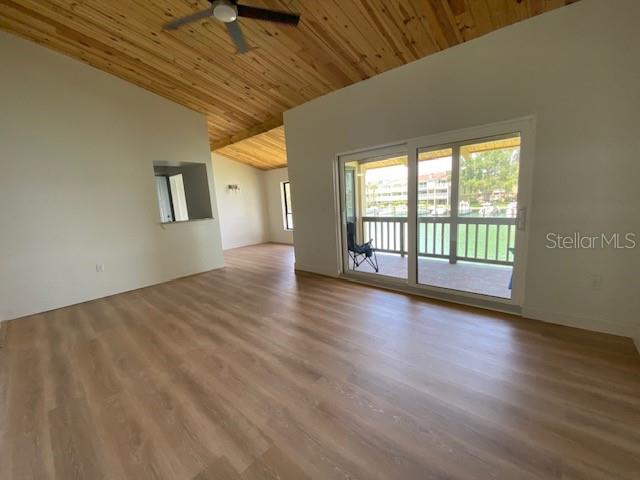 An interior room features light wood-look flooring, a vaulted wood-plank ceiling, and a sliding glass door — 542 PLAZA SEVILLE COURT UNIT 78, TREASURE ISLAND, FL