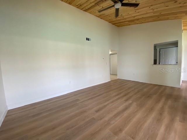 An empty room features light wood-look flooring, white walls, and a wood-paneled ceiling — 542 PLAZA SEVILLE COURT UNIT 78, TREASURE ISLAND, FL