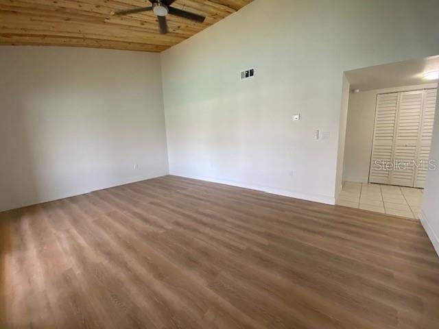 An empty room features light wood-look flooring, white walls, and a wood-paneled ceiling — 542 PLAZA SEVILLE COURT UNIT 78, TREASURE ISLAND, FL