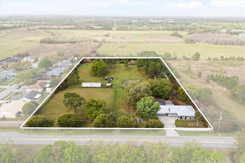 An aerial view shows a house on a large, fenced lot with trees and grass — 2270 OLD HICKORY TREE ROAD, ST CLOUD, FL