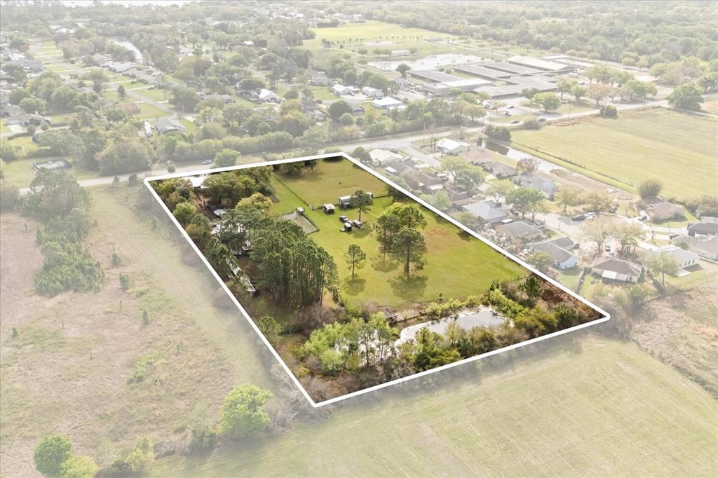 An aerial view shows a rectangular property with trees, a pond, and several small structures — 2270 OLD HICKORY TREE ROAD, ST CLOUD, FL