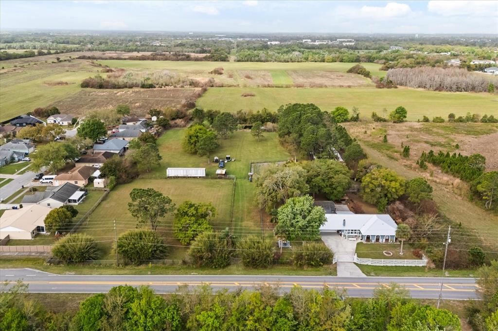 An aerial view shows a house with a large backyard and adjacent open fields — 2270 OLD HICKORY TREE ROAD, ST CLOUD, FL