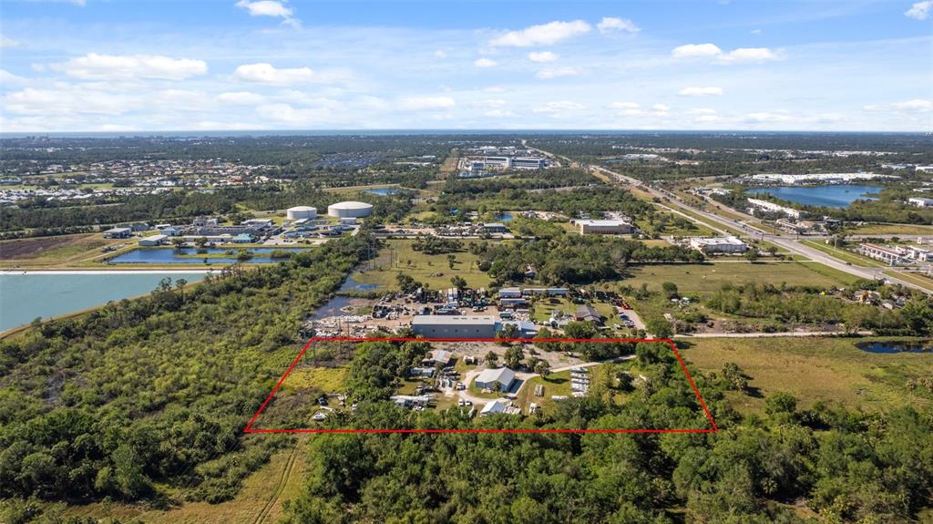An aerial view shows a rectangular lot with several small buildings surrounded by dense vegetation — 3530 LAUREL ROAD E UNIT A, NORTH VENICE, FL