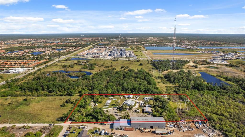 An aerial view shows a fenced industrial property with several buildings and outdoor storage areas — 3530 LAUREL ROAD E UNIT A, NORTH VENICE, FL