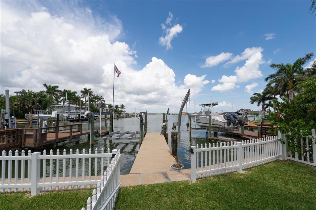 A wide entryway with wood-look flooring leads to an open living area with water views — 303 N BATH CLUB BOULEVARD N, NORTH REDINGTON BEACH, FL