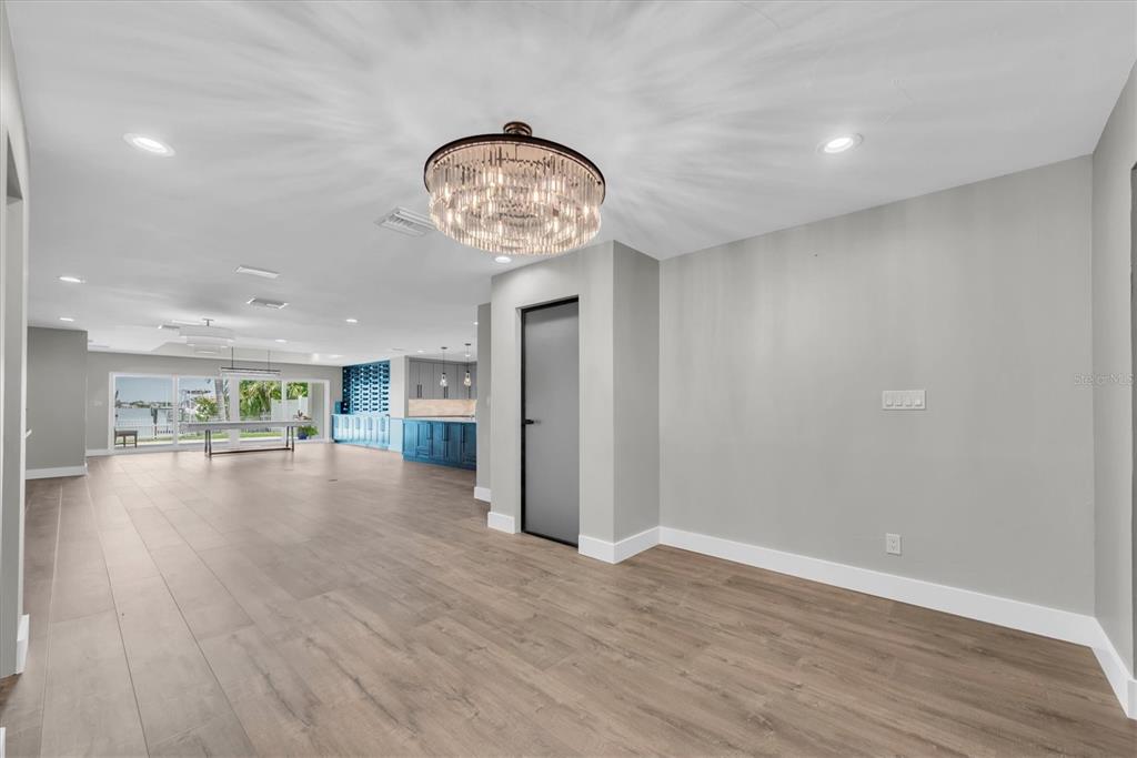 A modern kitchen featuring light gray cabinetry, stainless steel appliances, and a large white island — 303 N BATH CLUB BOULEVARD N, NORTH REDINGTON BEACH, FL