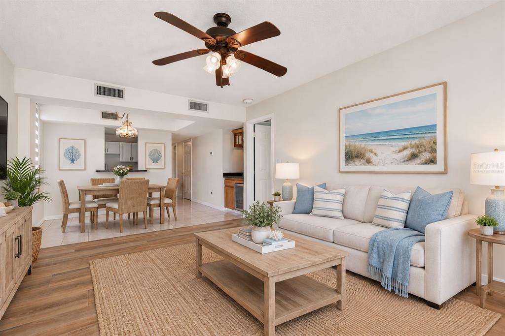 A living and dining area features wood-look flooring, tile, a ceiling fan, and sliding doors — 3360 OCEAN SHORE BOULEVARD UNIT 103, ORMOND BEACH, FL