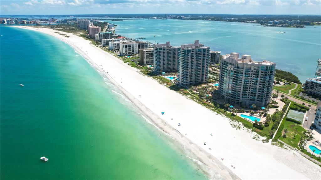 An aerial view of a white sand beach lined with high-rise condominiums and turquoise water — 1560 GULF BOULEVARD UNIT 1607, CLEARWATER, FL
