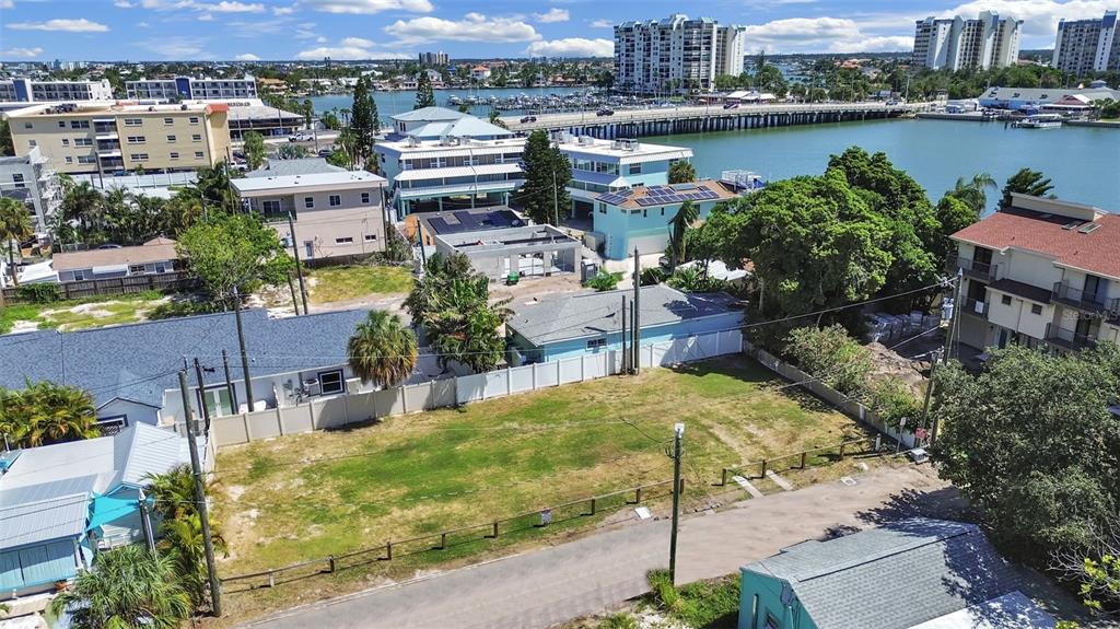 An aerial view shows a vacant, grassy rectangular lot situated in a coastal residential neighborhood — 140 92ND AVENUE, TREASURE ISLAND, FL