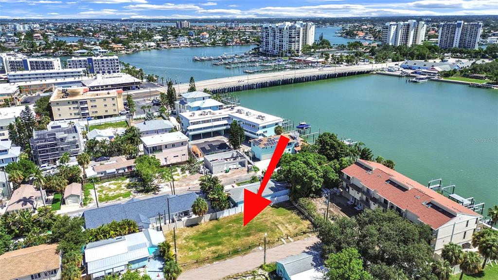 An aerial view shows a vacant grassy lot in front of several residential buildings — 140 92ND AVENUE, TREASURE ISLAND, FL