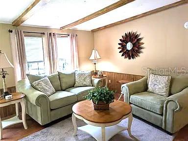 A living room features light green furniture, wooden ceiling beams, and a sunburst wall mirror — 56314 BLUE CREEK ROAD, ASTOR, FL