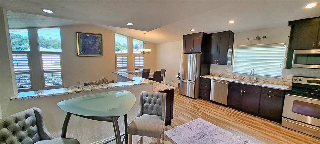 A living room with a large sectional sofa, patterned area rug, and open kitchen — 2400 LAUDERDALE COURT, ORLANDO, FL