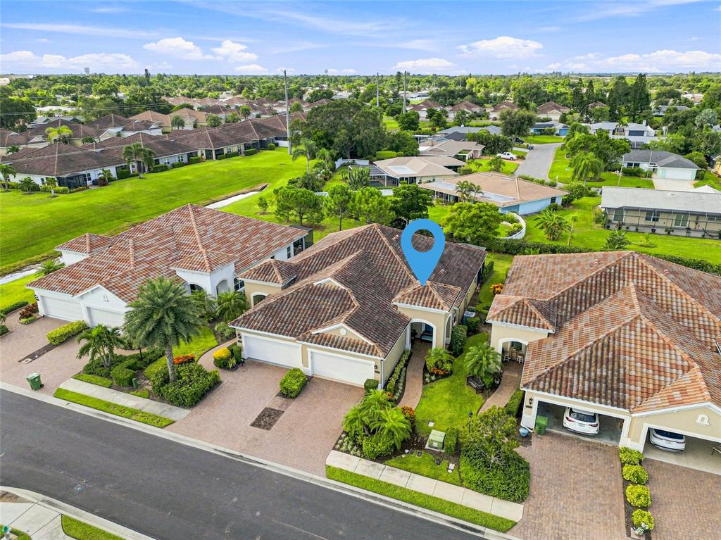 An aerial view of a residential neighborhood featuring several houses with tiled roofs — 7201 VISTA BELLA DRIVE, BRADENTON, FL