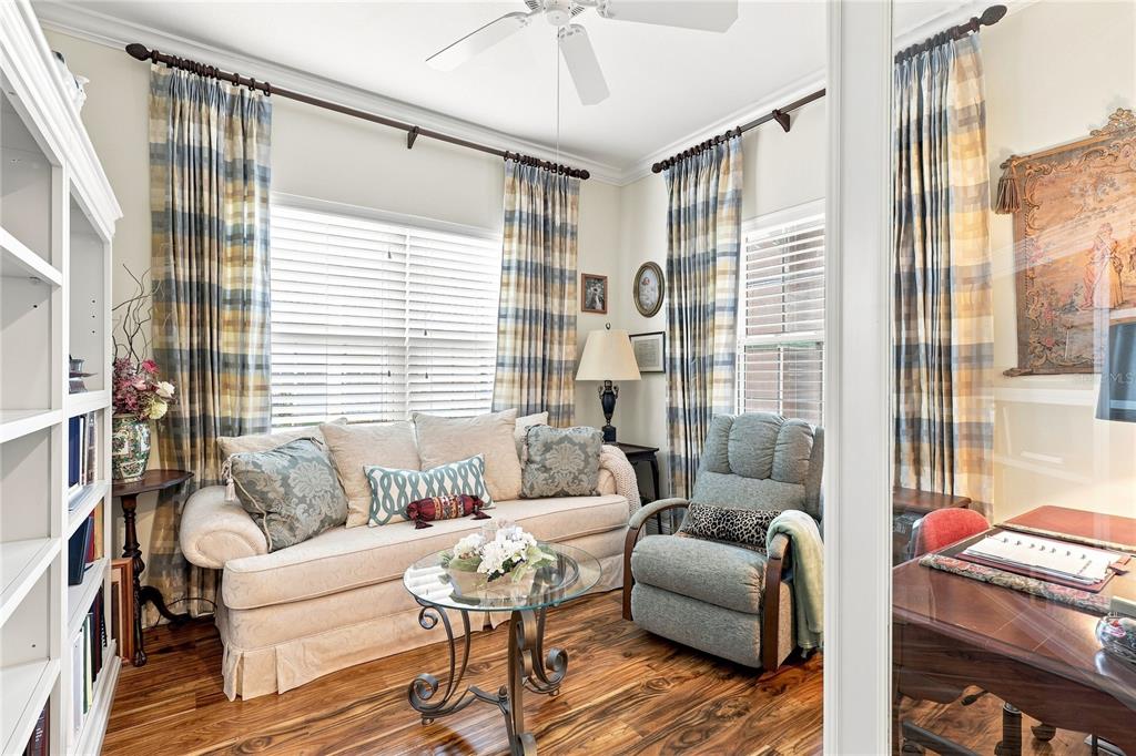 A cozy living room features a sofa, recliner, glass coffee table, and plaid floor-length curtains — 7201 VISTA BELLA DRIVE, BRADENTON, FL