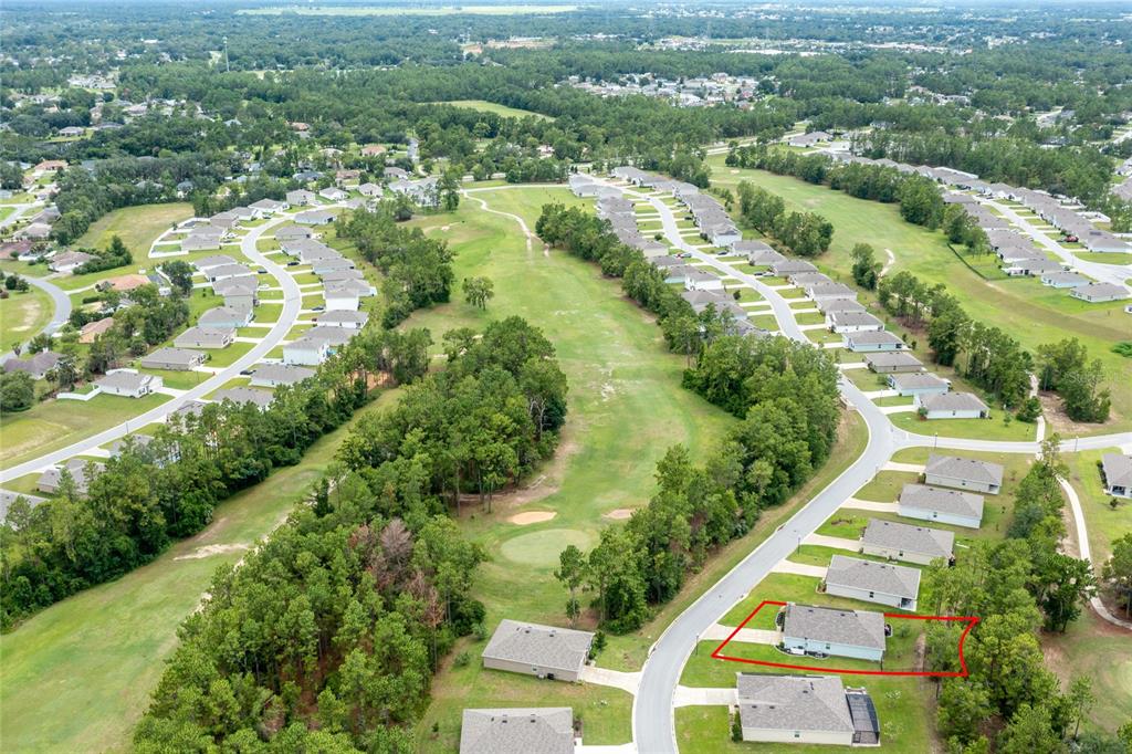 An aerial view shows a residential neighborhood with a house outlined in red near a golf course — 216 HICKORY COURSE, OCALA, FL
