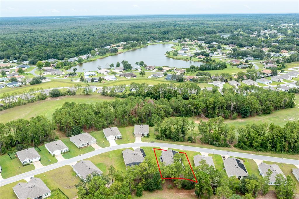 An aerial view shows a residential neighborhood with a highlighted lot and a nearby lake — 216 HICKORY COURSE, OCALA, FL
