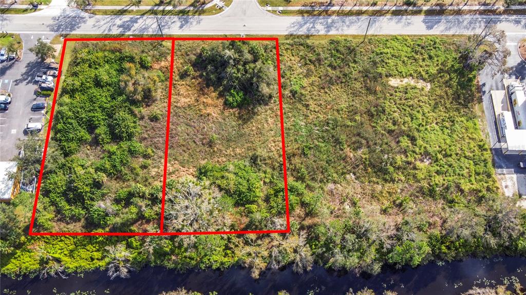 An aerial view shows two adjacent vacant lots outlined in red next to a parking lot — 2725 COMMERCE PARKWAY, NORTH PORT, FL