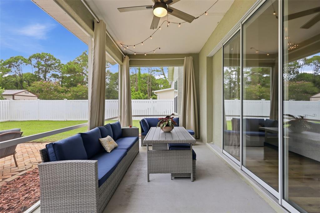 A living room features a vaulted ceiling, a sectional sofa, and a wood-paneled accent wall — 96 PARKVIEW DRIVE, PALM COAST, FL