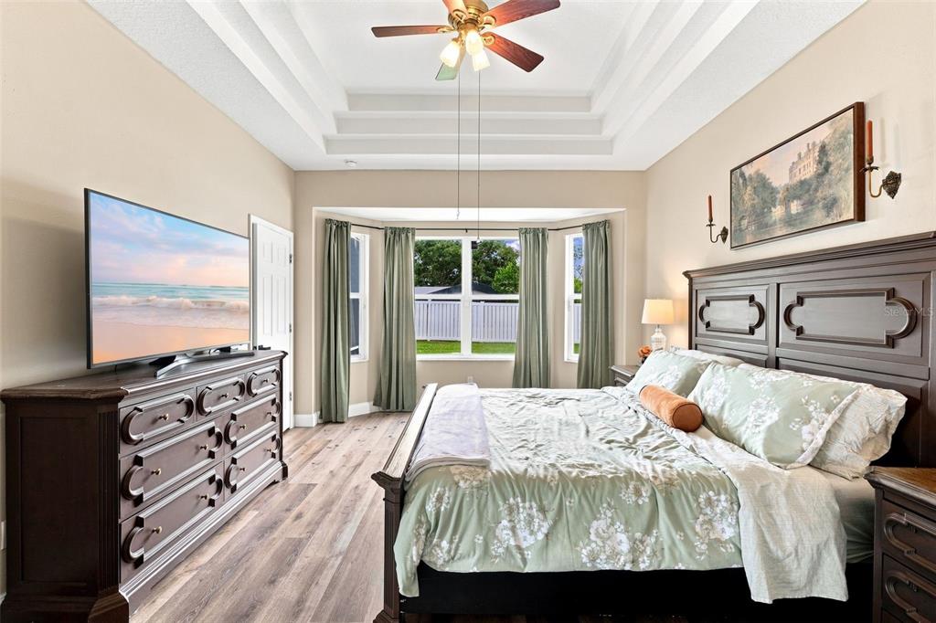A screened-in patio features a wicker sofa, dining table, and views of a fenced yard — 96 PARKVIEW DRIVE, PALM COAST, FL