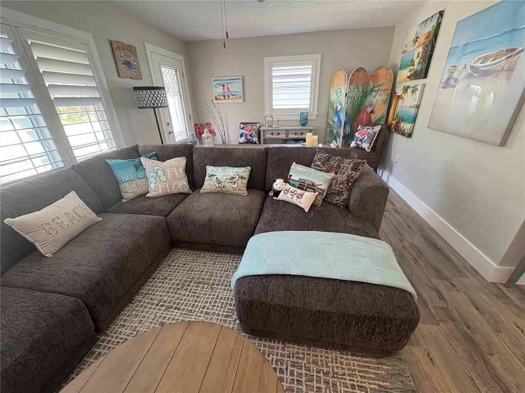 A living room features a large gray sectional sofa, a light blue throw, and beach-themed decor — 1517 S CENTRAL AVENUE, FLAGLER BEACH, FL