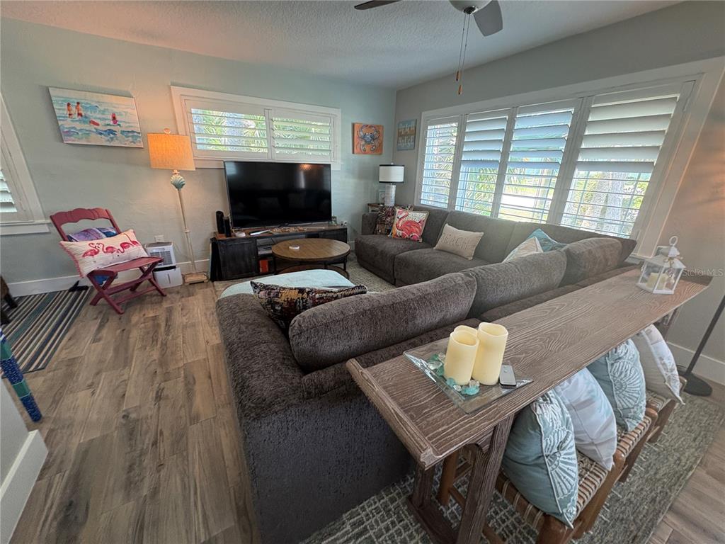 A living room features a gray sectional sofa, a television, and a wooden console table — 1517 S CENTRAL AVENUE, FLAGLER BEACH, FL