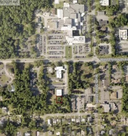 This is an aerial map showing a vacant lot outlined in red near a hospital — 0 WEST PLYMOUTH AVENUE, DELAND, FL