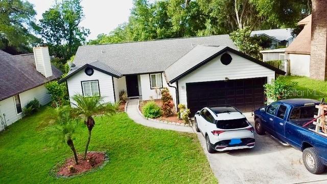 An elevated view of a single-story house with a white exterior, garage, and two vehicles — 957 SOUTHRIDGE TRAIL, ALTAMONTE SPRINGS, FL