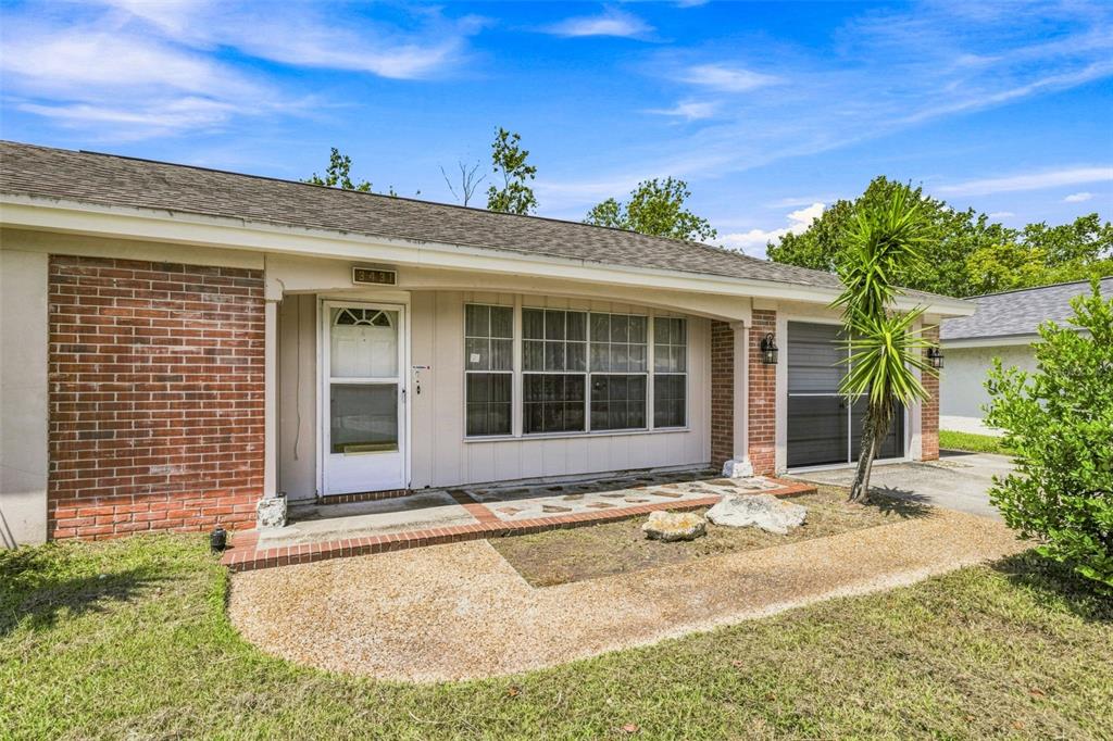 A single-story house with a brick and siding exterior, a front porch, and a driveway — 3431 OVERLAND DRIVE, HOLIDAY, FL