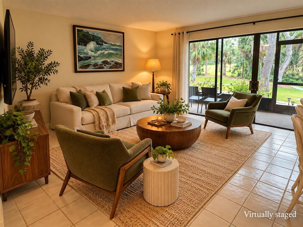 A virtually staged living room features a beige sofa, two green armchairs, and a sliding door — 3025 QUAIL HOLLOW UNIT 3025, SARASOTA, FL
