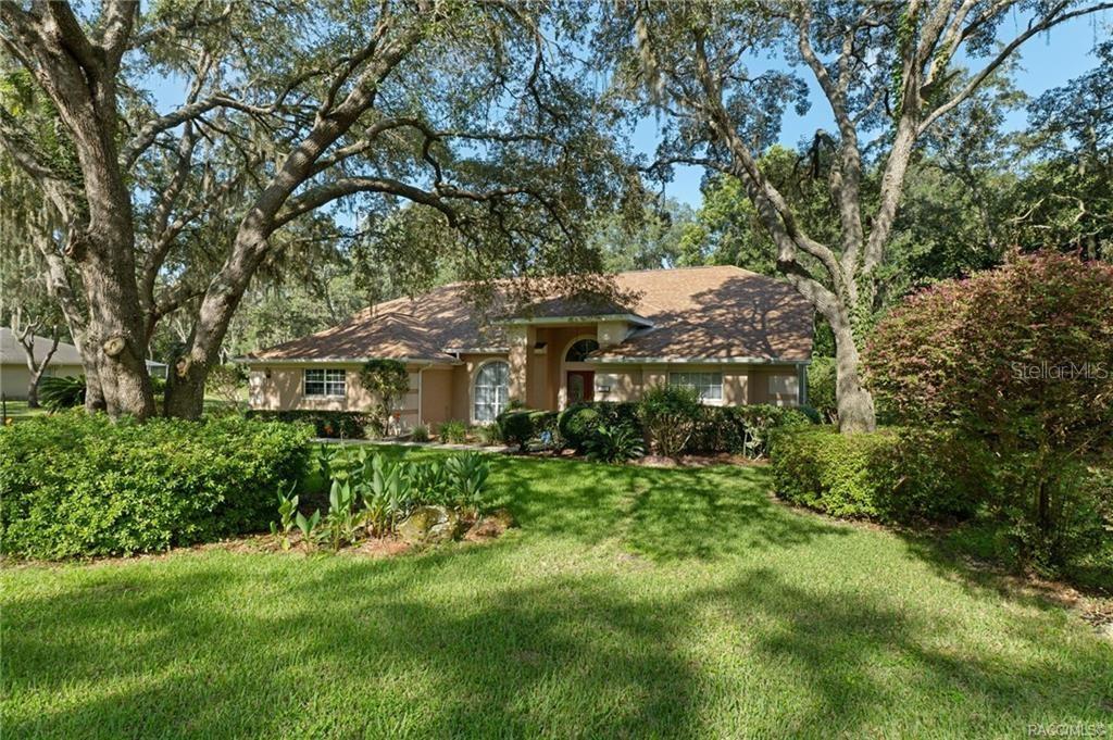 A single-story house with a tan exterior and a brown shingled roof sits among trees — 270 N GRANDVIEW AVENUE, HERNANDO, FL