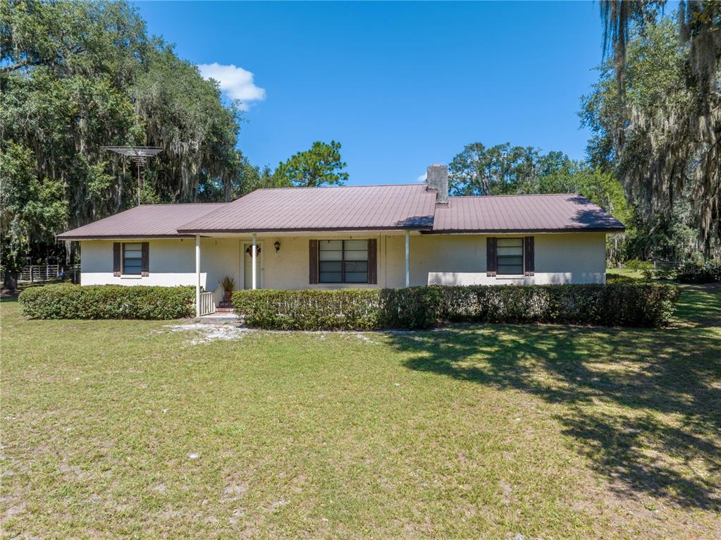 A single-story house with a metal roof and a front porch sits on a grassy lot — 1360 S STATE ROAD 19, PALATKA, FL