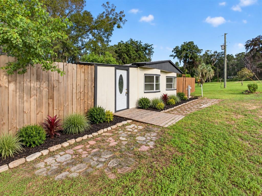 The exterior of a tan house features a dark roof, a white door, and windows — 6287 MAGNOLIA STREET, KEYSTONE HEIGHTS, FL