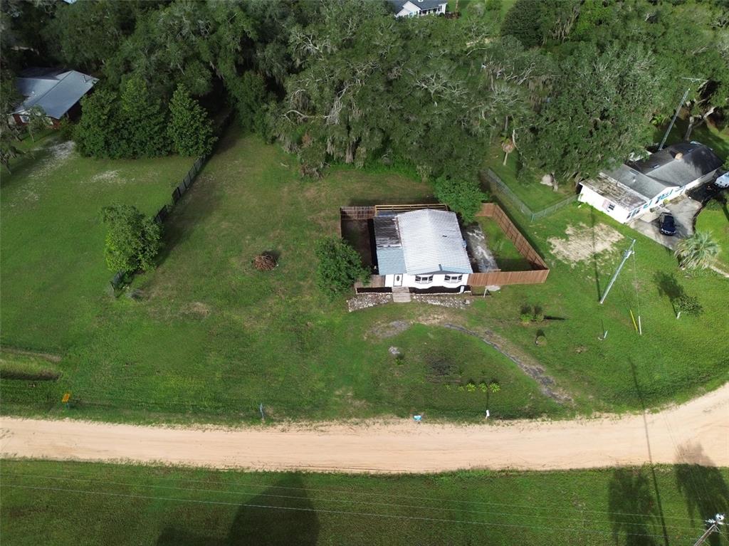 A wooden gate opens to a cracked concrete patio enclosed by a wooden privacy fence — 6287 MAGNOLIA STREET, KEYSTONE HEIGHTS, FL