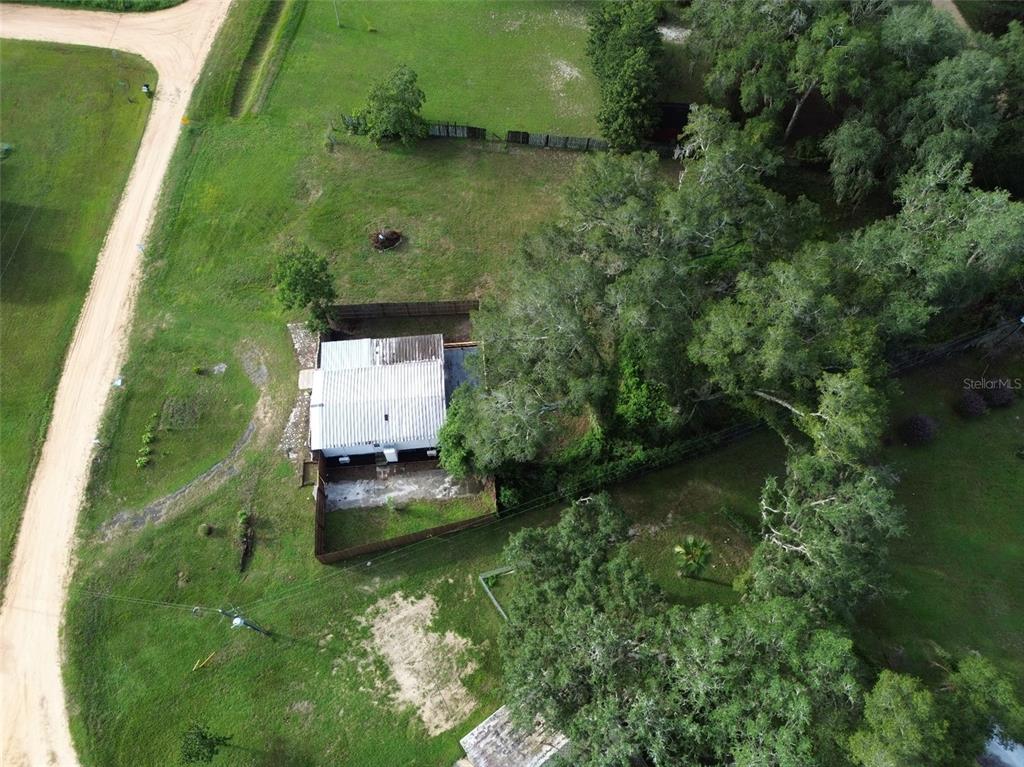 A cracked concrete driveway leads to a wooden privacy fence in a grassy backyard — 6287 MAGNOLIA STREET, KEYSTONE HEIGHTS, FL