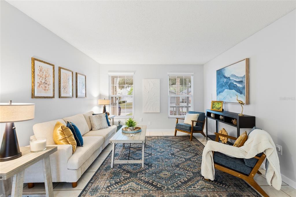 A living room features a beige sofa, two blue armchairs, and a patterned area rug — 7608 WILLOW PARK DRIVE, TEMPLE TERRACE, FL