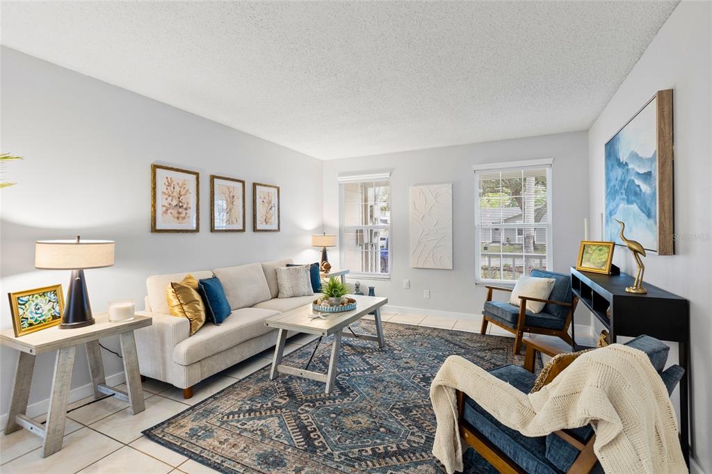 A living room features a beige sofa, two blue armchairs, and a patterned area rug — 7608 WILLOW PARK DRIVE, TEMPLE TERRACE, FL
