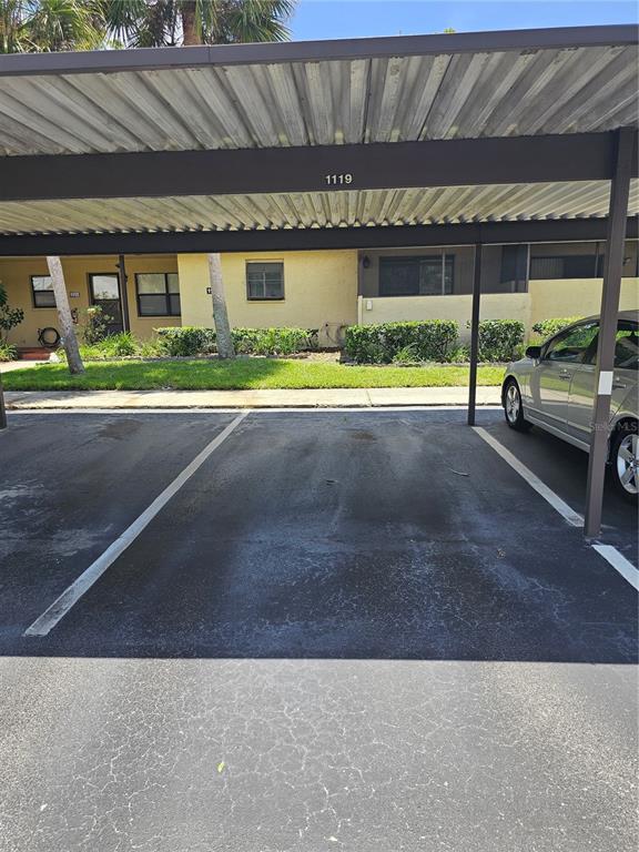 A covered parking space with a numbered beam sits in front of a residential building — 1119 9TH CIRCLE SE UNIT 1119, LARGO, FL