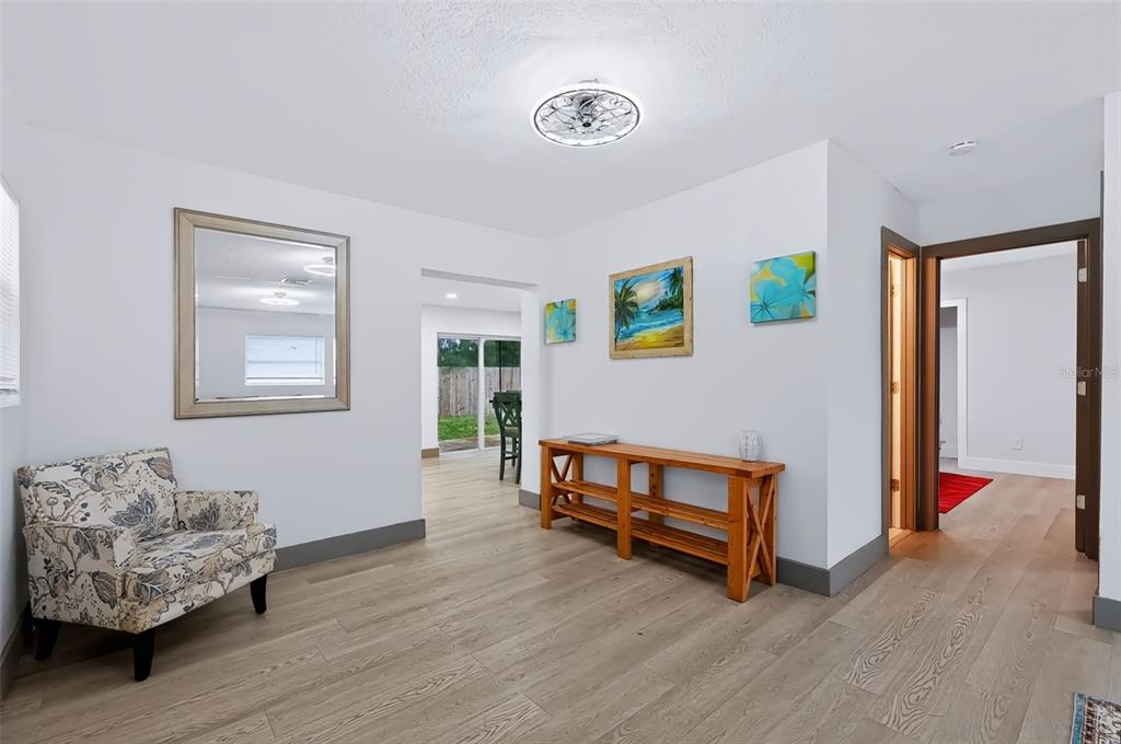 An empty room with white walls, light wood-look flooring, a white door, and two windows — 6691 56TH AVENUE N, ST PETERSBURG, FL