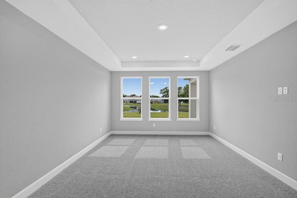 A bright bathroom features dual white vanities, marble-style flooring, and a glass-enclosed walk-in shower — 16237 ALPHA GROVE PLACE, ODESSA, FL