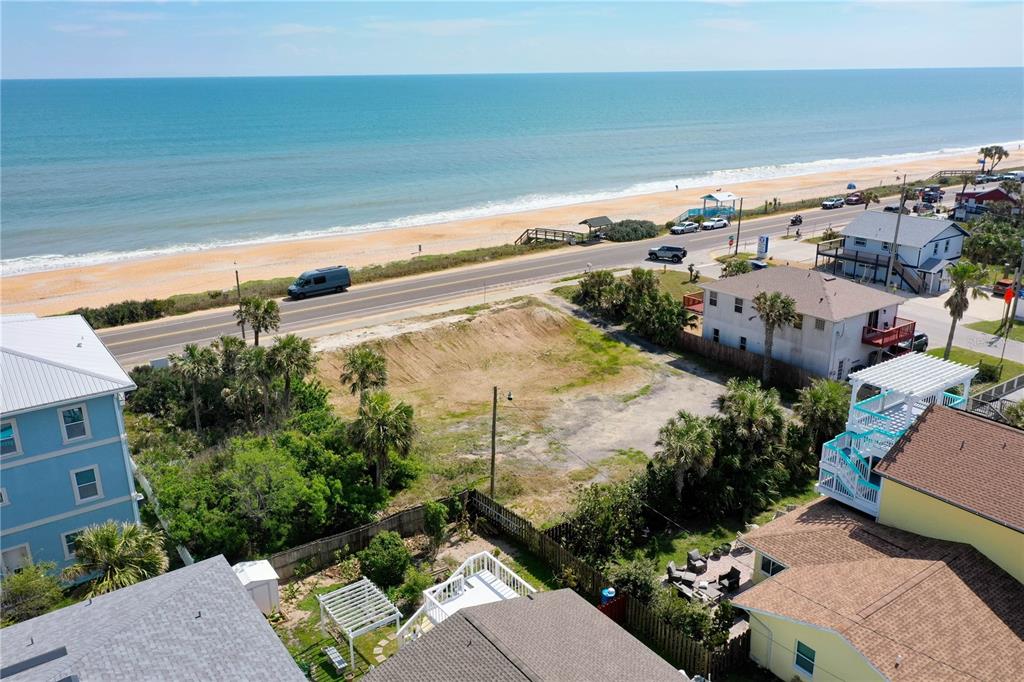 An aerial view shows a vacant coastal lot situated between houses near a beach road — 1005 N OCEAN SHORE BOULEVARD, FLAGLER BEACH, FL