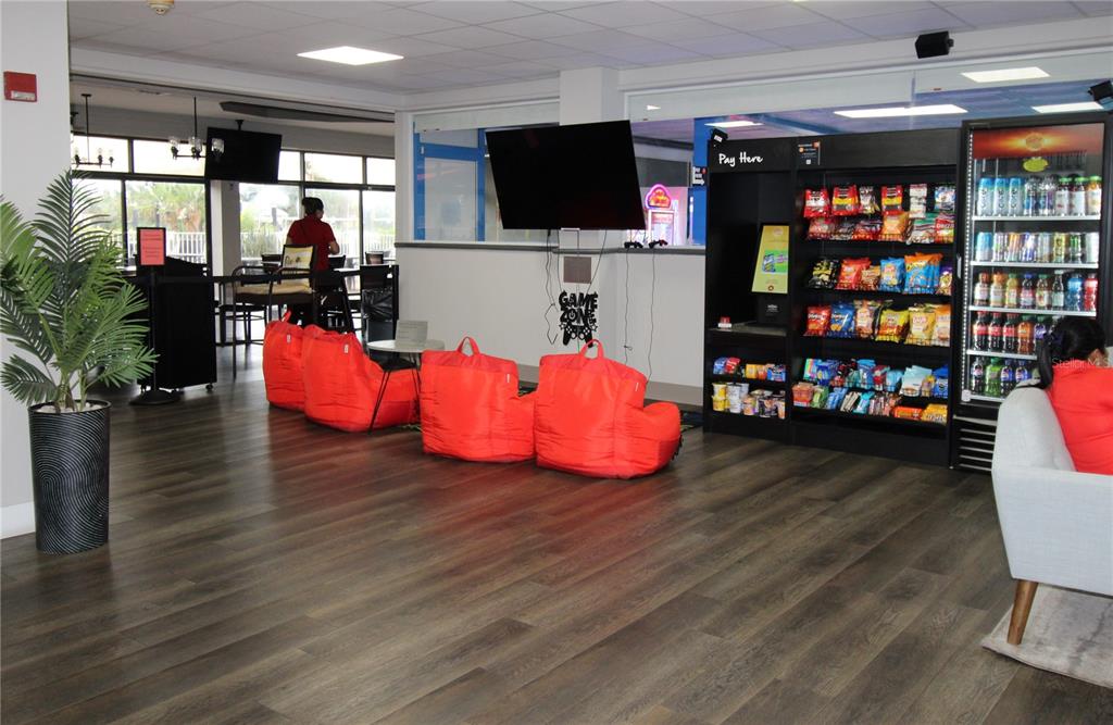 A lounge area features wood-look flooring, red beanbag chairs, a television, and a snack vending machine — 7150 N TAMIAMI TRAIL UNIT C226, SARASOTA, FL