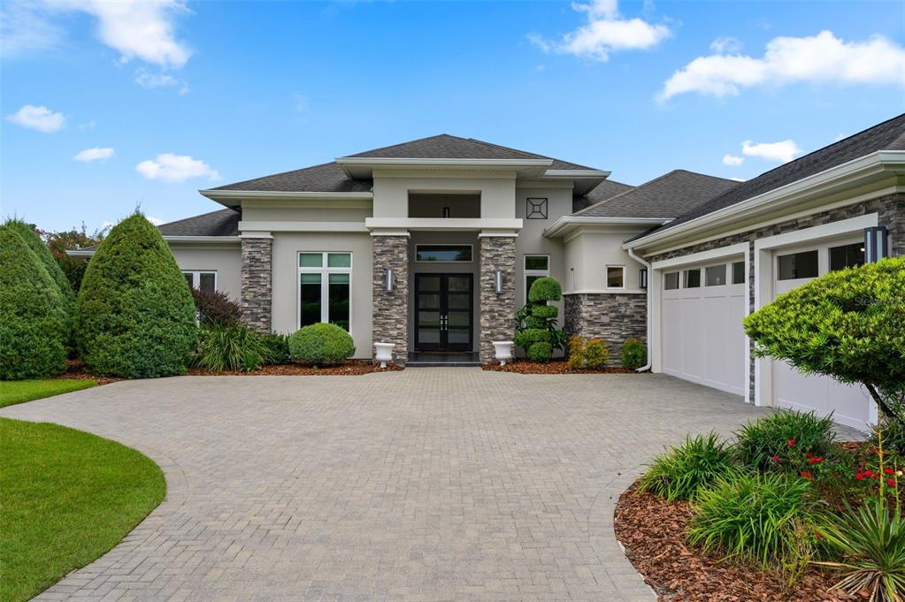 A modern single-story house features a stone facade, a paved driveway, and a double-door entrance — 2807 SW 117TH STREET, GAINESVILLE, FL