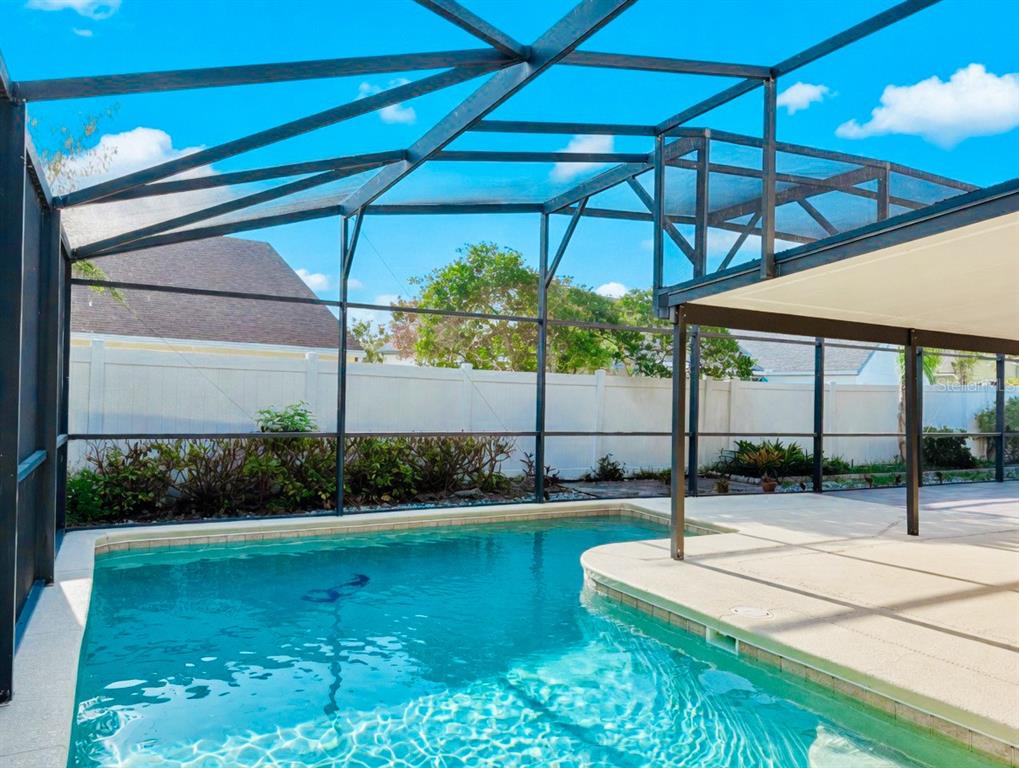 A tan single-story house with a two-car garage and a white fence at sunset — 343 LYTTON CIRCLE, ORLANDO, FL