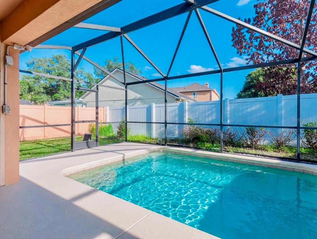 A tan single-story house features a white garage door, double front doors, and a lawn — 343 LYTTON CIRCLE, ORLANDO, FL