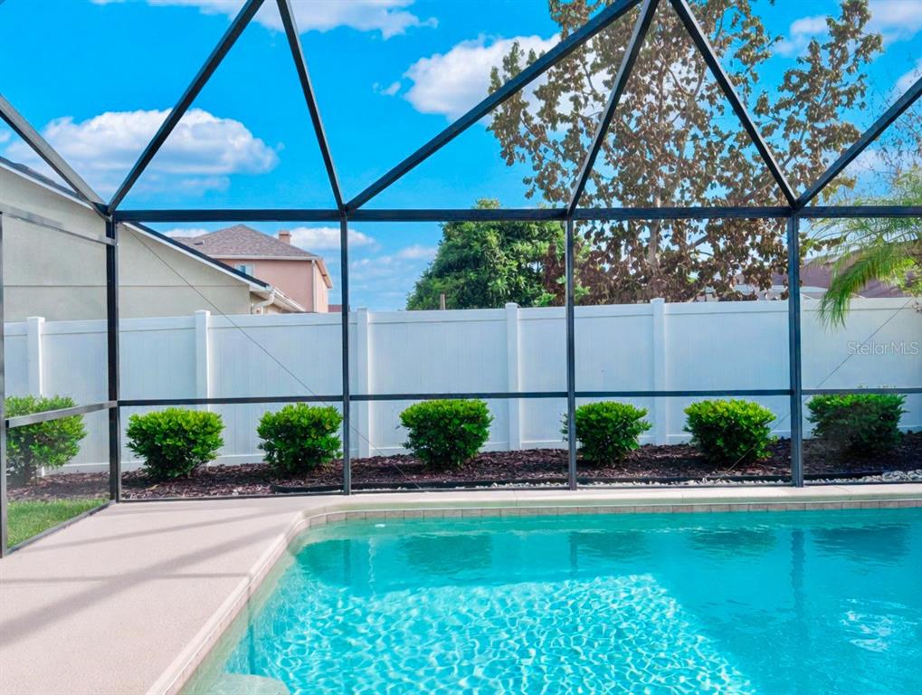 A tan single-story house with a two-car garage and a large tree in the front yard — 343 LYTTON CIRCLE, ORLANDO, FL