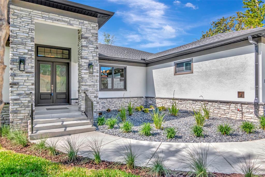 An aerial view of a single-story house with a gray roof, white walls, and stone accents — 108 IRWIN STREET E, SAFETY HARBOR, FL