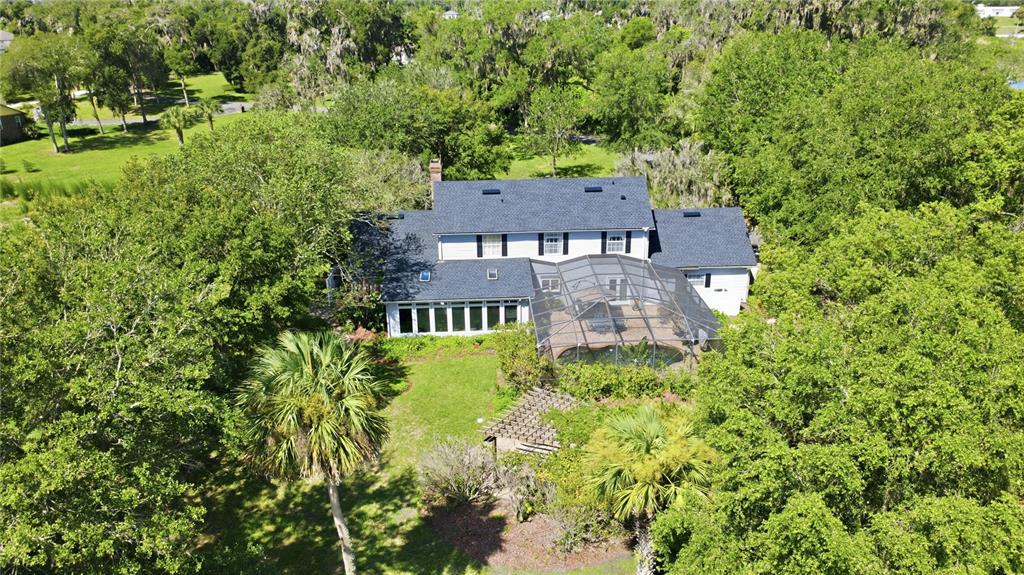A single-story house with a dark roof, gray siding, and a yellow front door at dusk — 1245 WESTOAK DRIVE, DELAND, FL