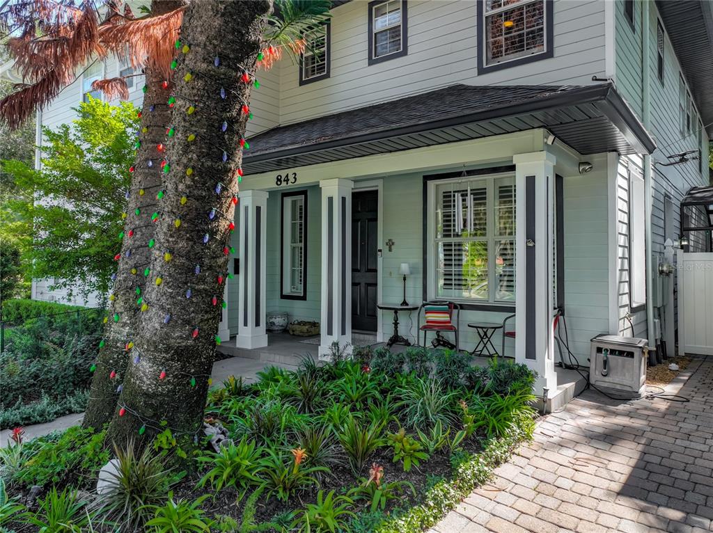 The exterior of a two-story house features a covered front porch with a dark door — 843 ALTALOMA AVENUE, ORLANDO, FL
